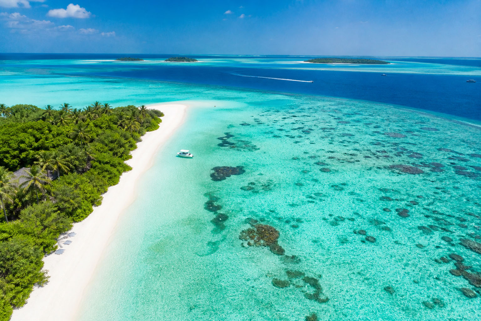 Maldives tour package from Kolkata 2026 - pristine beach and turquoise lagoon aerial view