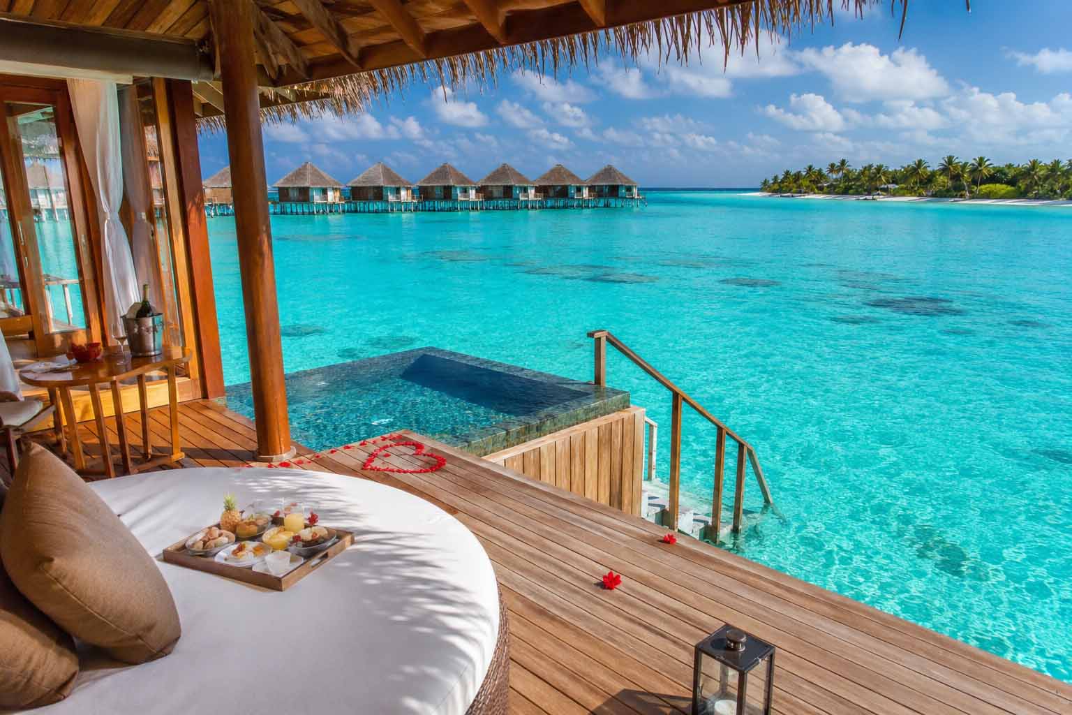 Romantic overwater villa in Maldives honeymoon resort with turquoise lagoon